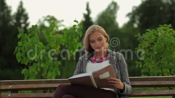 坐在公园长椅上的女学生视频的预览图