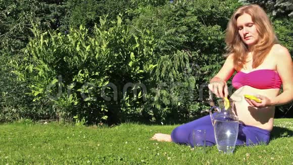 健康孕妇将柠檬片放入盛有水的玻璃瓶中视频的预览图