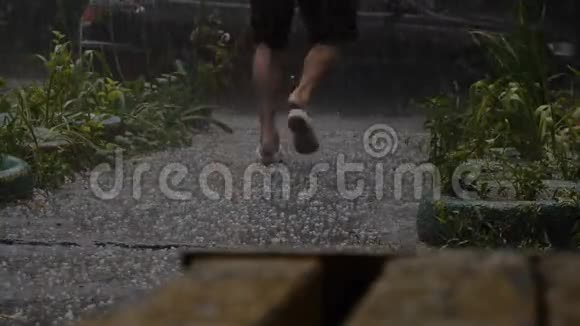 人从沥青路上的大雨中跑出来静态拍摄视频的预览图