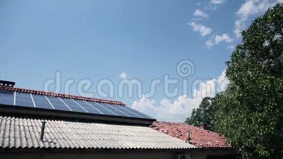 后面有云的屋顶上的太阳能电池板视频的预览图