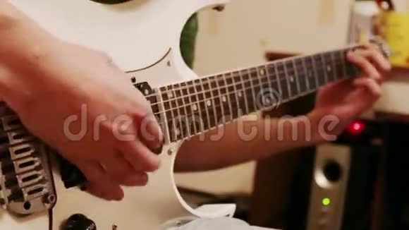 年轻人弹现代白色吉他的手视频的预览图
