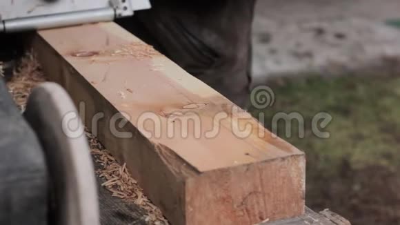 在刨木机上工作的人芯片从刨床的不同侧面飞视频的预览图