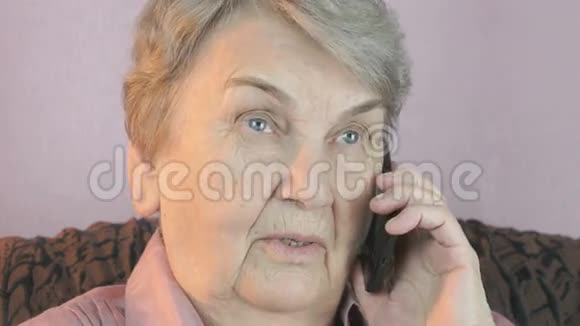 80多岁的老年妇女在手机上微笑交谈视频的预览图