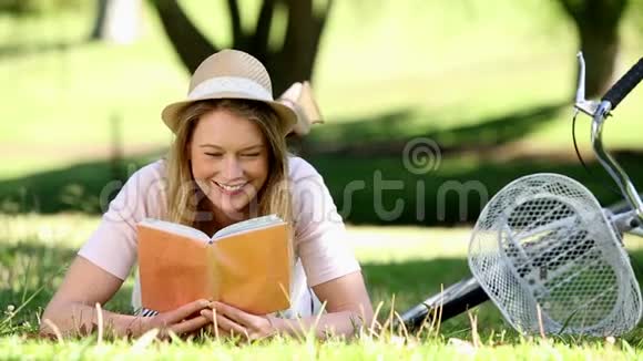 在公园里骑自行车旁边看书的漂亮女孩视频的预览图