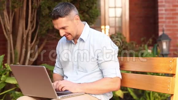 快乐的讲师坐在长凳上用笔记本电脑视频的预览图