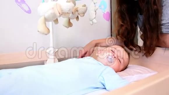 快乐的母亲照看婴儿床上的儿子视频的预览图