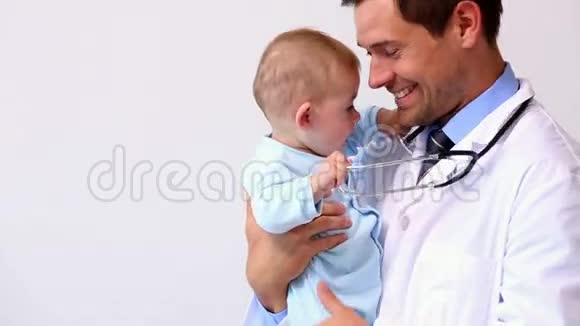 英俊的儿科医生抱着小男孩视频的预览图
