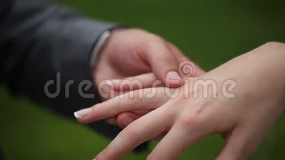 新郎和新娘互相佩戴结婚戒指特写镜头视频的预览图