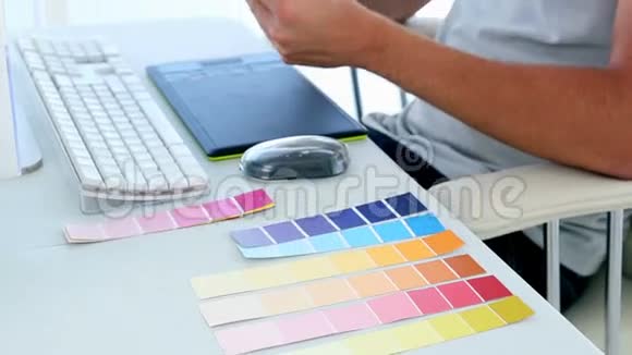 平面设计师在办公桌前看彩色样品视频的预览图
