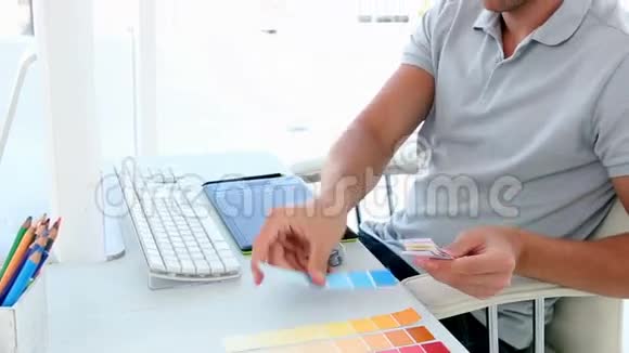 平面设计师在办公桌前看彩色样品视频的预览图
