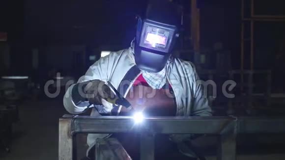 黑暗工厂的Tig焊接带面罩的工人技师慢动作视频的预览图