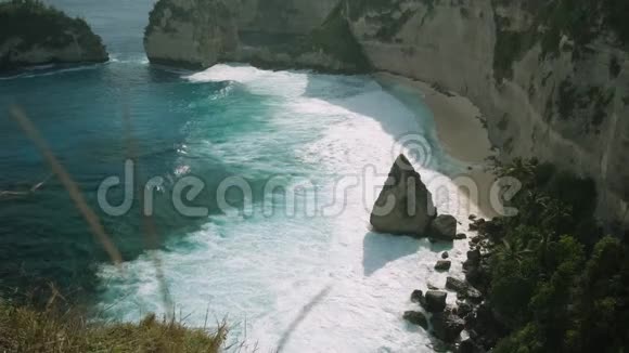 在印度尼西亚努沙佩尼达岛的Atuh海滩美丽的手掌在海洋中的岩石视频的预览图