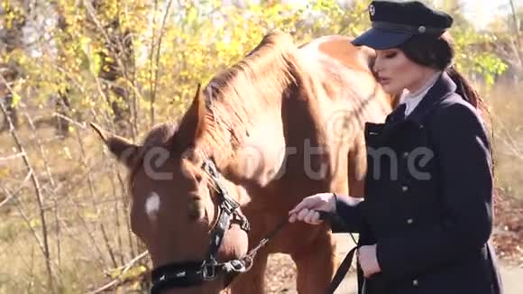 秋天穿着特别衣服戴着棕色马帽的漂亮女孩的肖像视频的预览图