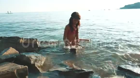 小女孩用石头和石头在海里洗澡少女少女在生活方式的浪花上游泳视频的预览图