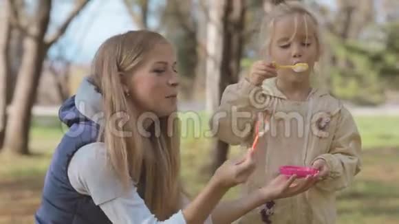 妈妈和女儿在公园里吹泡泡视频的预览图