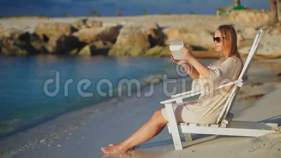 一个拿着垫子拍海的女人坐在视频的预览图