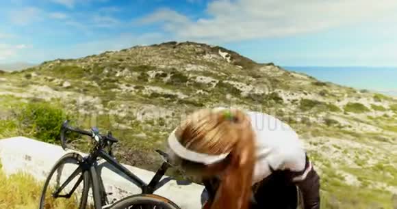 在乡村道路修理自行车的女自行车视频的预览图