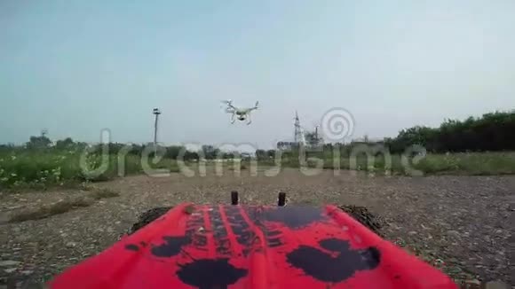 RC汽车带着摄像机在土路上行驶拍摄了四架直升机在汽车前飞行视频的预览图