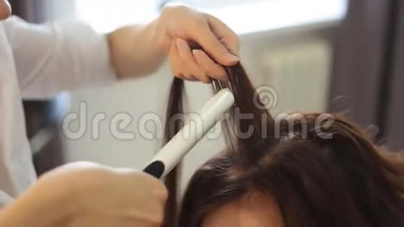 年轻女性和理发师在发廊做发铁视频的预览图