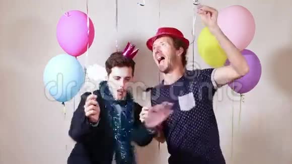两个快乐的男人在摄影棚里用道具跳舞视频的预览图
