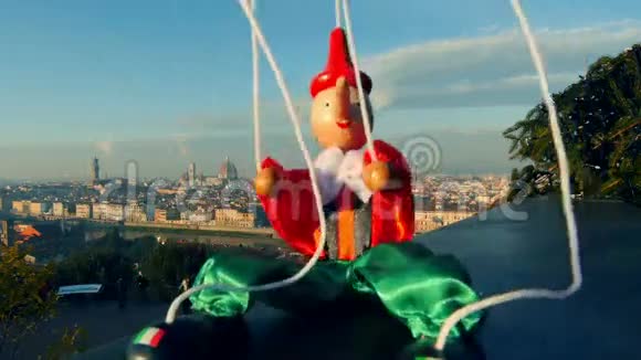 意大利佛罗伦萨木偶皮诺奇坐在城市景观前面视频的预览图