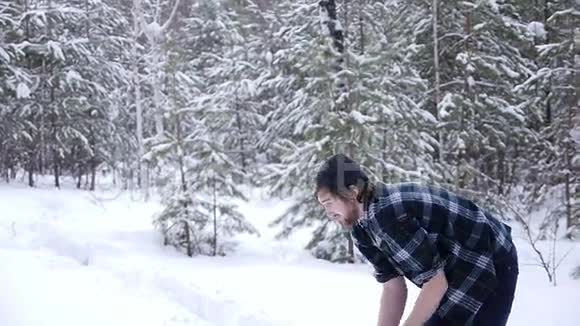 伐木工人在冬天的森林里砍斧砍柴视频的预览图