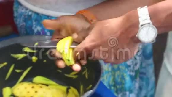 在斯里兰卡Kandy一个卖芒果的小贩用刀切芒果视频的预览图