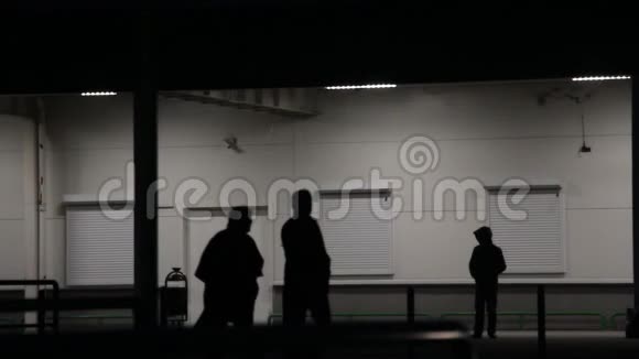 戴帽子的人晚上站在墙边视频的预览图