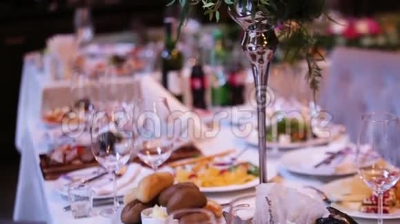 漂亮的婚礼装饰由不同种类和颜色的花在一家高档餐厅的婚礼桌上视频的预览图