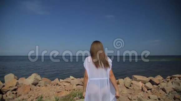 美丽的无忧无虑的白种人女孩享受她的海滩生活方式在海滩上摆姿势跳舞视频的预览图