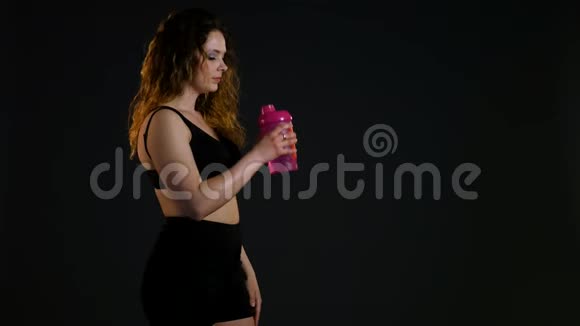运动女孩喝瓶水健身房里的女人喝淡水运动后口渴的女人肖像画视频的预览图