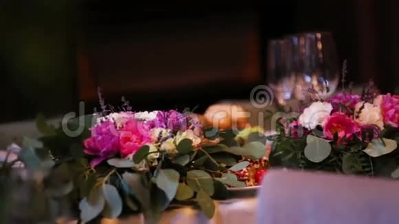 漂亮的婚礼装饰由不同种类和颜色的花在一家高档餐厅的婚礼桌上视频的预览图