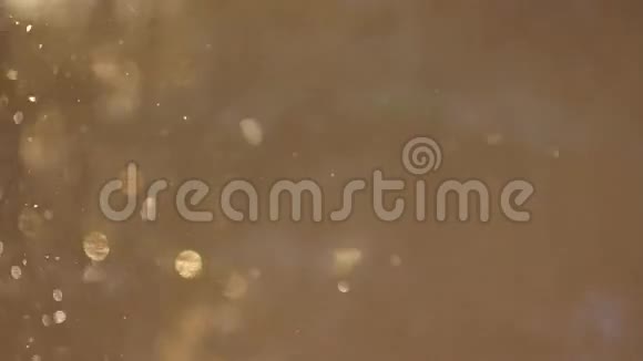 在阳光下落下的金色雪背景视频的预览图