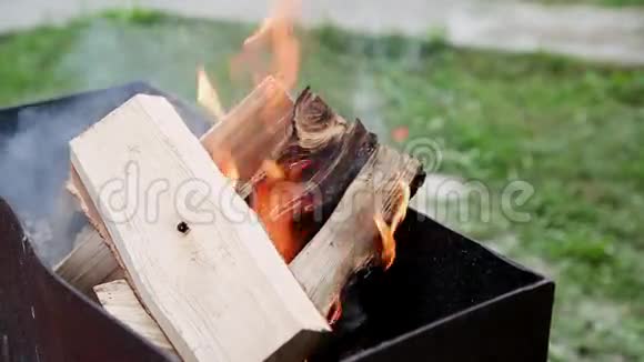 在户外的烤架里生火烧木头视频的预览图