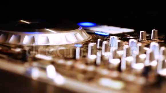 DJ调整各种轨道控制装置在DJ混频器在夜总会视频的预览图