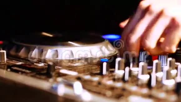 DJ调整各种轨道控制装置在DJ混频器在夜总会视频的预览图