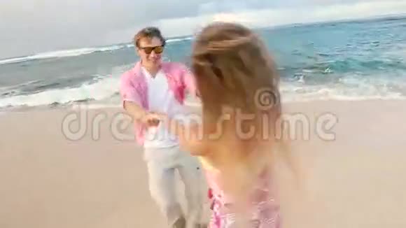 有魅力的健康夫妇在海滩上一起跑步很开心视频的预览图