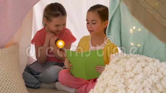 快乐女孩在家的孩子帐篷里看书视频的预览图