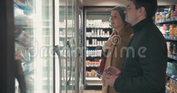 年轻夫妇从冰箱里拿冷冻食品视频的预览图