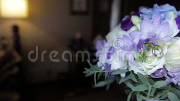 婚礼戒指在一束白色的花上结婚戒指和深蓝色的花束快关门婚礼视频的预览图