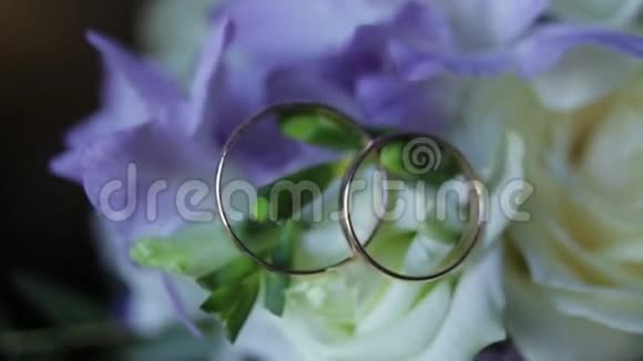 婚礼戒指上的一束白色的花紧拢结婚戒指和深蓝色的花束快关门婚礼视频的预览图