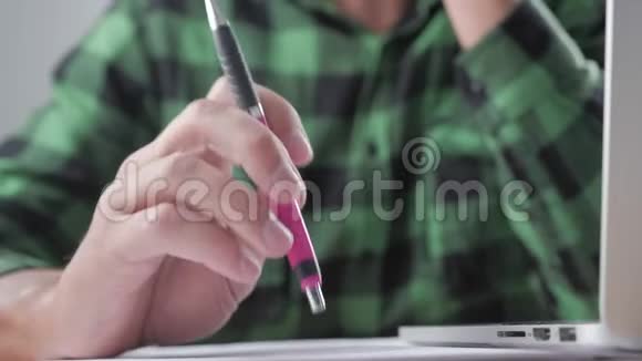 疲倦的商人在工作场所等着什么用钢笔做紧张的动作视频的预览图