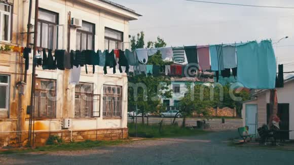在城市贫困地区的一栋多层建筑的绳索上称重和烘干衣服视频的预览图