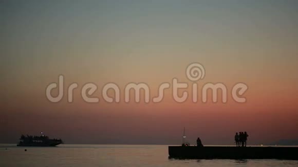 一群人在大海的背景上日落时的剪影夏季海滩视频的预览图