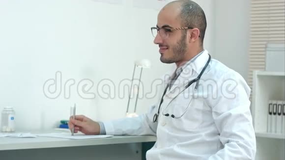 积极的男性医生在办公室与病人交谈视频的预览图