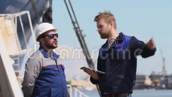 两名带笔记本电脑的工程师在航运货运港进行通讯视频的预览图