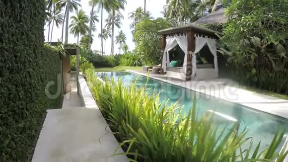 巴厘岛印度尼西亚2016年11月热带度假胜地的领土景观池棕榈树和躺椅视频的预览图