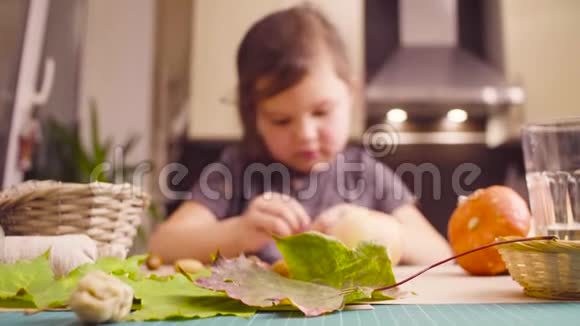 坐在书桌前的小女孩用橡子做项链视频的预览图