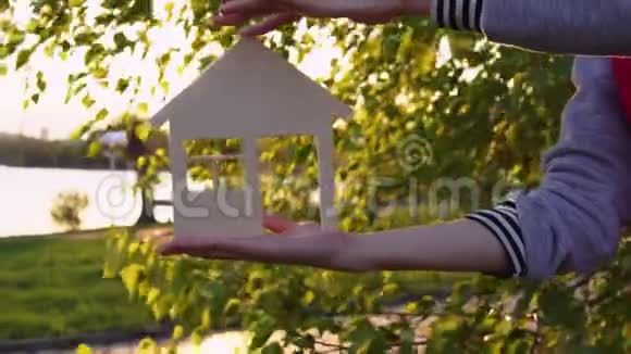 日落时人类的手握住了房子视频的预览图