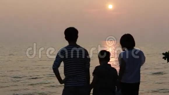 亚洲家庭看日落海背景视频的预览图